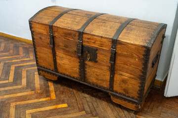 Wooden chest of drawers stands on an old wooden parquet floor. Retro furniture