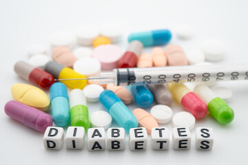 Diabetes word with pills and capsules medical drug.