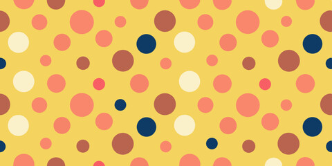 A vibrant yellow background features a playful pattern of variously sized multicolored circles in pink, cream, brown, and navy blue.