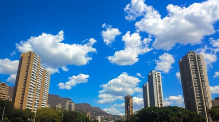 High-rise residential flats towering into a vivid blue sky with soft white clouds, seen from street level