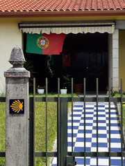 typical entrance to the garden in front of a Portuguese home with shell sign  for the St. James way in Portugal