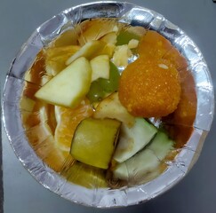 Indian Street Food Fruit with Sweet Ladoo in Foil Bowl