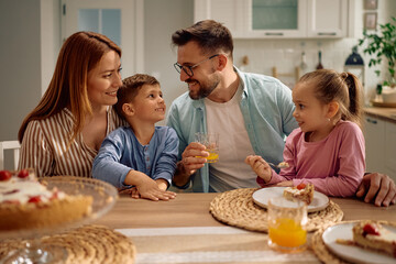 Happy family enjoying in dessert at dining table.
