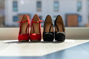 2 pairs of women's pumps in a row on the floor in front of a window