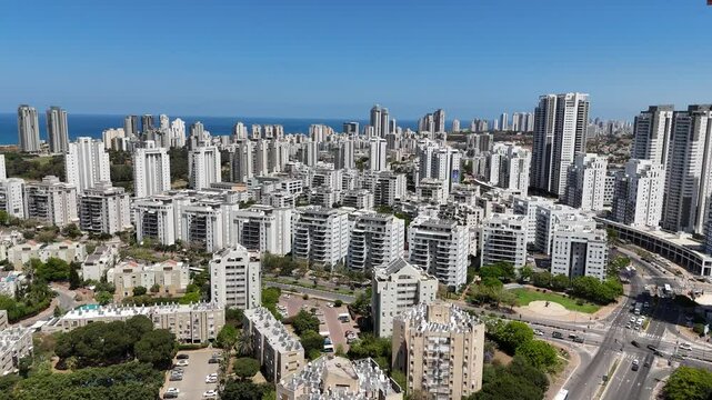 Aerial drone view of Netanya, a coastal city in central Israel. The scene showcases residential buildings, the Mediterranean Sea, cliffs, and urban development along the shoreline.