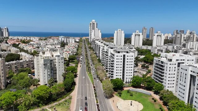 Aerial drone view of Netanya, a coastal city in central Israel. The scene showcases residential buildings, the Mediterranean Sea, cliffs, and urban development along the shoreline.