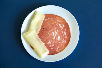 Close-up of a sliced bologna on a white plate