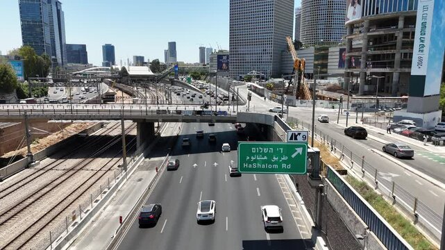 Aerial drone view of Tel Aviv, Israel, featuring the Azrieli Towers, Ayalon Highway, and dense city traffic. Urban skyline and infrastructure captured during daytime. 
