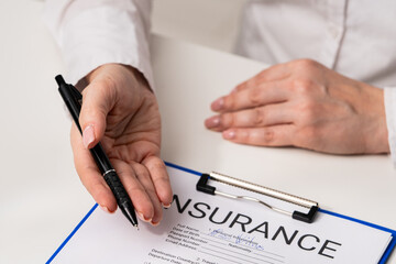 Signing Insurance Document with Pen Held by Professional