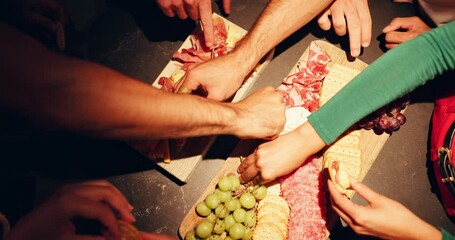 Food, hands and people with eating from charcuterie board at night for dinner, nutrition or hungry. Above, friends and snacks selection for social gathering, organic diet or healthy meal for wellness - Powered by Adobe