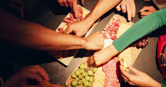 Food, hands and people with eating from charcuterie board at night for dinner, nutrition or hungry. Above, friends and snacks selection for social gathering, organic diet or healthy meal for wellness