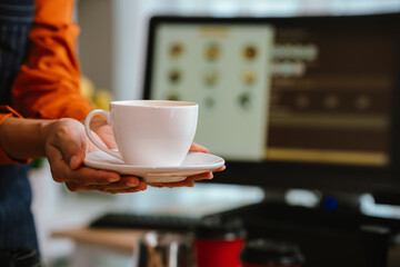 Barista in coffee shop preparing espresso drinks, working with coffee machine in a comfortable indoor atmosphere, representing small business and service.