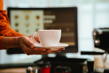 Barista in coffee shop preparing espresso drinks, working with coffee machine in a comfortable indoor atmosphere, representing small business and service.