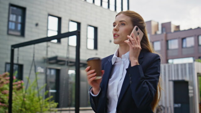 Energetic businesswoman calling cellphone walking street with coffee closeup. - Powered by Adobe
