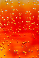 Bright orange liquid filled with fizzy bubbles captures the light