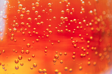 Bright orange liquid filled with fizzy bubbles captures the light