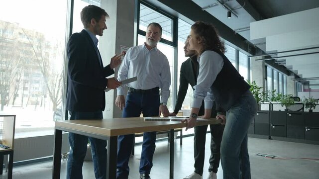 Executive business team people group working with paperwork standing at table, analyzing corporate strategy, reviewing plan, managing financial project overview at office meeting.