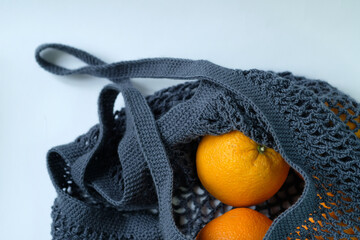 oranges in a blue knitted mesh bag