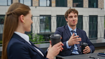Relaxed businessman businesswoman talking at coffee break on terrace closeup.