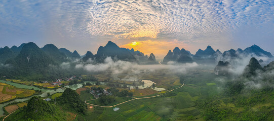 amazing aerial view of colorful sky at sunrise over mountains. The serene landscape, dotted with valleys and rivers, creates a mesmerizing contrast against the glowing clouds. wonderful landscape