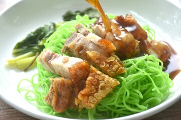 Chinese jade noodles topping roasted crispy pork dipping sweet soy sauce on plate 