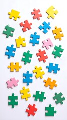 Naklejka premium Colorful jigsaw puzzle pieces scattered on white background