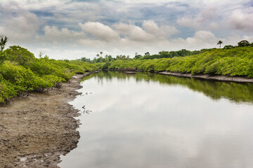 A mighty river with anchored fishing and transport boats and canoes.