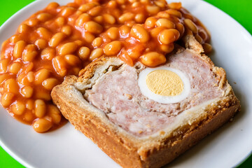 A Slice Of Pork And Egg Classic Gala Pie With Baked Beans