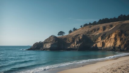 Fototapeta premium A beautiful view of a beach and ocean with a rocky hill in the background. The sky is clear and the water is calm.