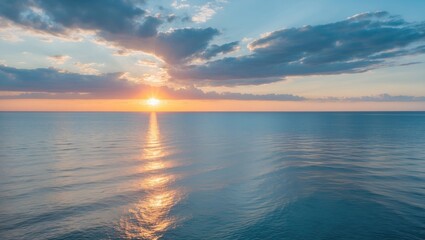 Obraz premium Sunset over the ocean with clouds and calm water, capturing the beauty of the sea at dusk.