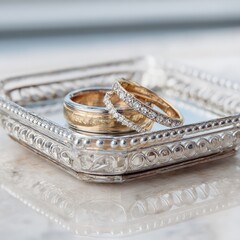 Wedding rings gold diamond bands on vintage silver tray engagement jewelry close up detail shot luxury