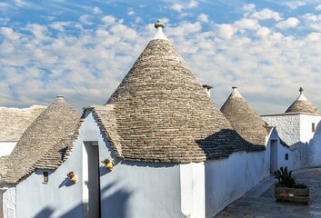 Touristic italian town near Bari of Alberobello with ancient beautiful buildings trulli with white...
