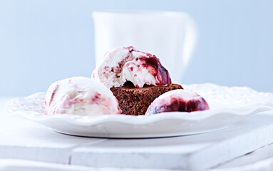 Strawberry ice cream with chocolate and cherry syrup on chocolate brownie. Selective focus.