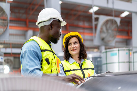 female engineer supervisor advice technician foreman to inspect and check spare part equipment of production machine, team of diverse workers working together at industrial manufacturing factory