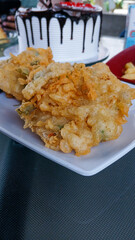 Tempe mendoan with crispy flour in a white square plate. side view.