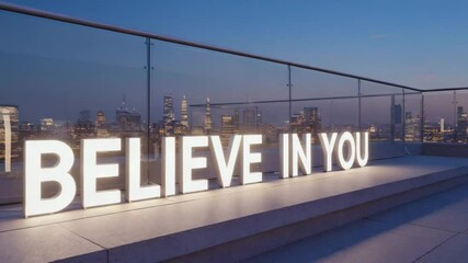 Illuminated sign reading 'Believe in You' on a rooftop terrace with a city skyline at dusk. The scene conveys inspiration and urban life.