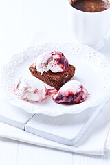 Strawberry ice cream with chocolate and cherry syrup on chocolate brownie. Selective focus.