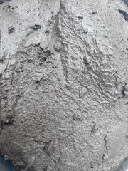 The cement looks freshly mixed, likely still in the process of setting or being prepared for pouring or shaping. The color is a typical grayish hue associated with cement or concrete.