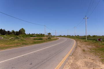 Asphalt road turning left.