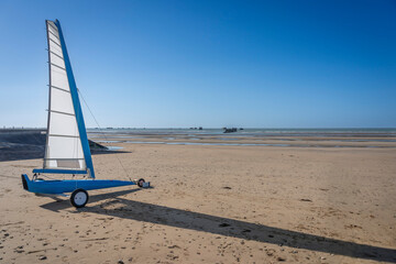 Asnelles-Sur-Mer, France - 05 16 2025:  View of a white and blue competition land yacht, a wheeled...