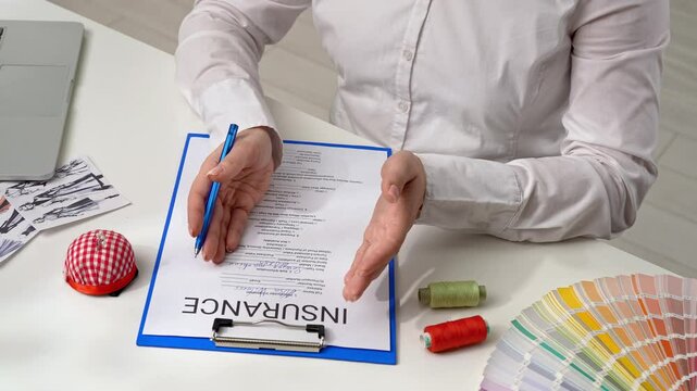 Person Signing an Insurance Document with a Blue Pen