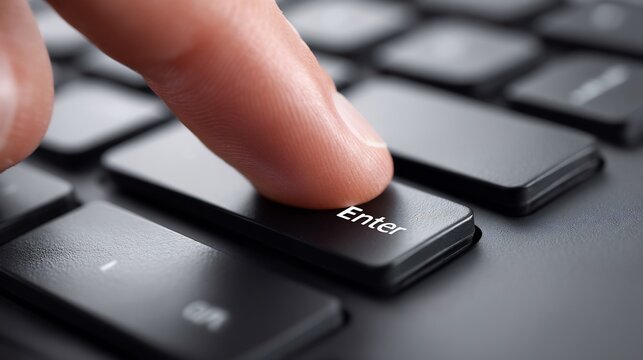 Finger presses the enter key on a computer keyboard.