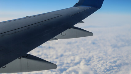 Obraz premium celestial view out of an airplane window with wing and clouds in view. travel background or design element