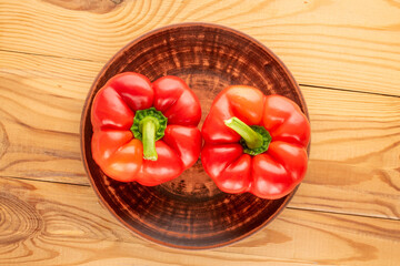 Sweet red peppers with home accessories on a wooden table, close-up, top view.