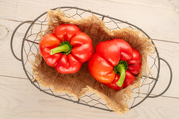 Sweet red peppers with home accessories on a wooden table, close-up, top view.