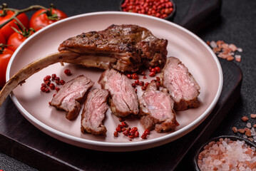 Juicy meat on the bone or rack of lamb. Grilled veal with salt, spices and herbs