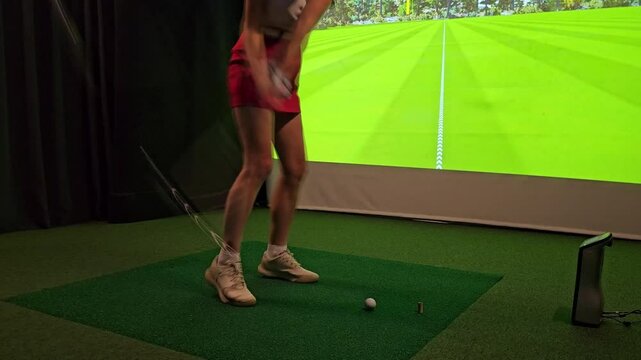 Golf practice session at indoor facility focusing on swing technique and precision on virtual course