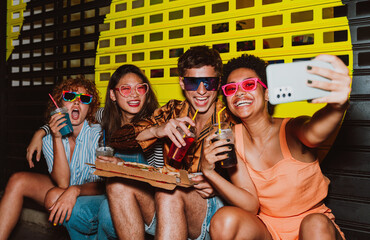 Friends going out in the evening and making party. Young people meeting outdoor in the weekend and celebrating together.