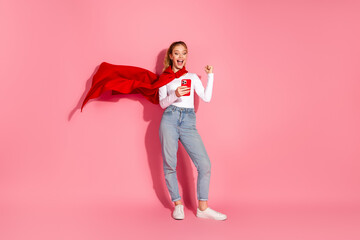 Young cheerful woman in casual style gesturing with exciting energy while holding a smartphone...