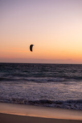 Sunset view of Scarborough Beach in Perth, Australia. with silhouette of a person kitesurfing or skysurfing, surf with a parachute